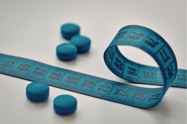 GLP-1 pill with measuring tape